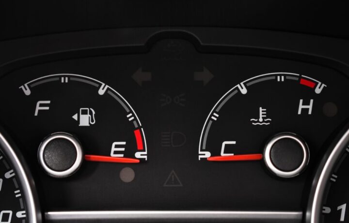 Detailed view of a car's fuel and temperature gauges on dashboard.